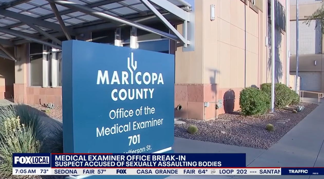 Sign for Maricopa County Office of the Medical Examiner. News header reports a break-in and accusations of assemblage assault