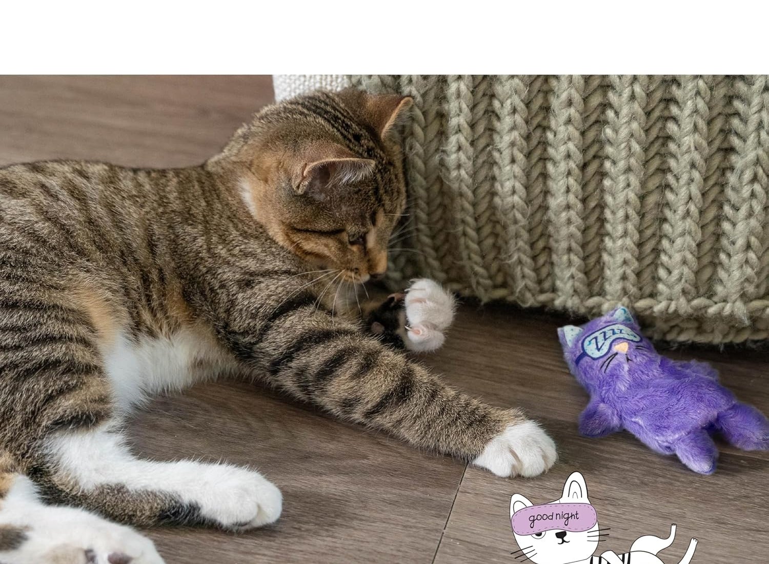 Cat lying connected  the level  adjacent  to a knitted pillow and a purple catnip artifact  labeled "goodnight," suggesting relaxation for easing anxiety