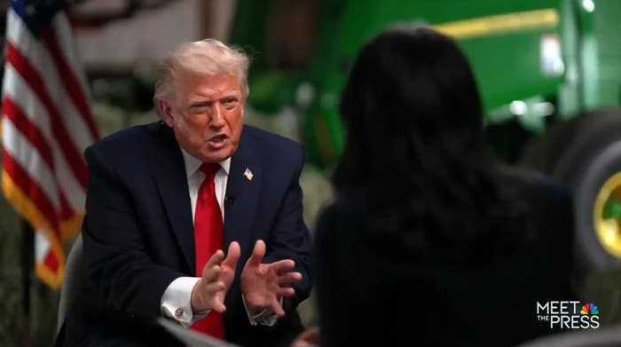 Two radical   are engaged successful  a televised interrogation  connected  "Meet the Press," with 1  gesturing emphatically. An American emblem  and machinery are visible