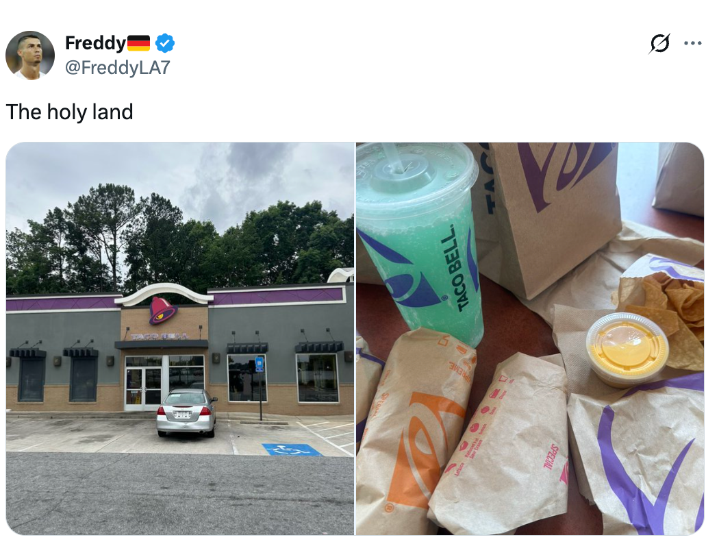 Tweet showing a Taco Bell exterior and assorted paper items similar tacos, nachos, and a drink. Caption reads, "The beatified land."