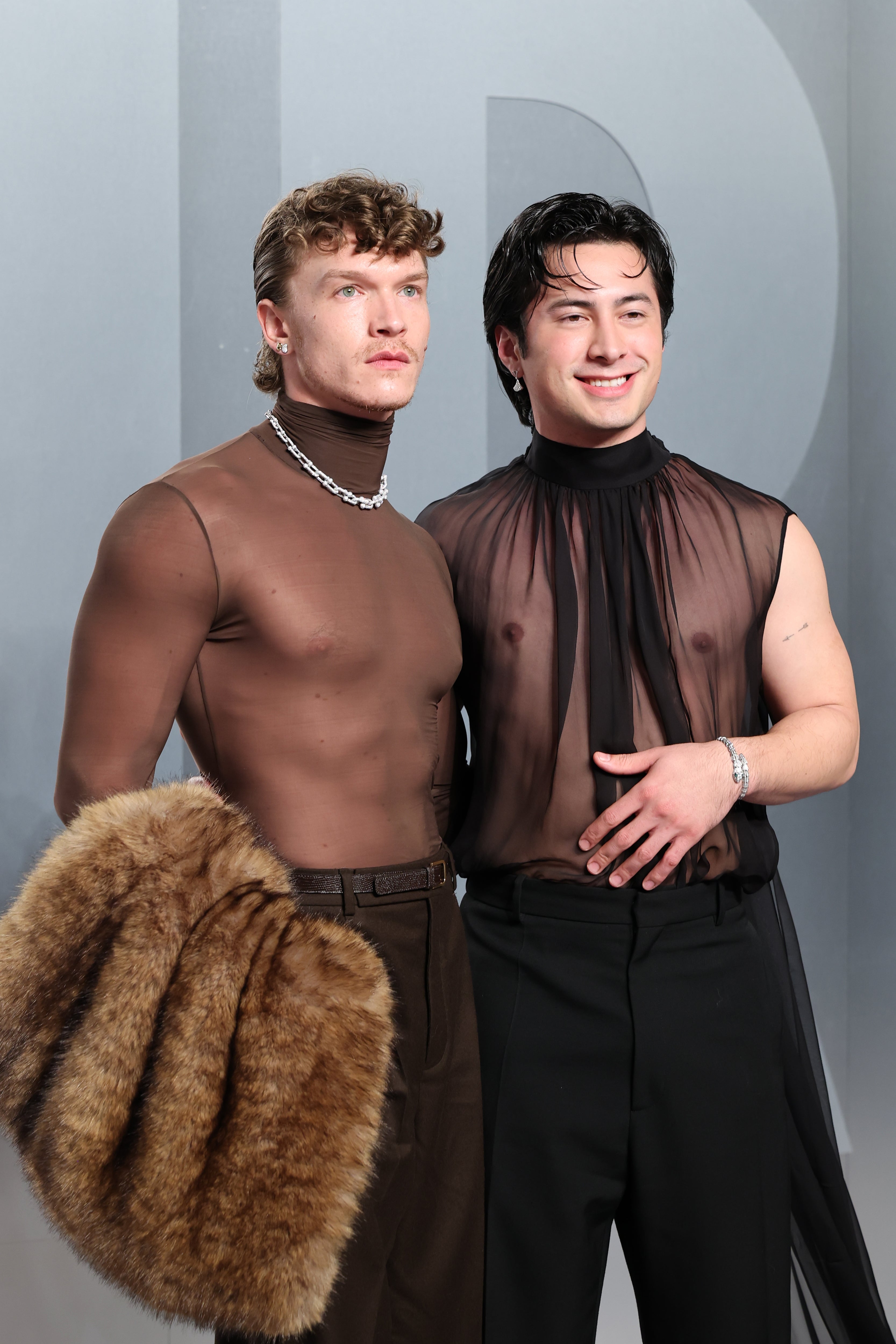 Two individuals airs connected a reddish carpet. Both deterioration sheer shirts; 1 holds a fur shawl