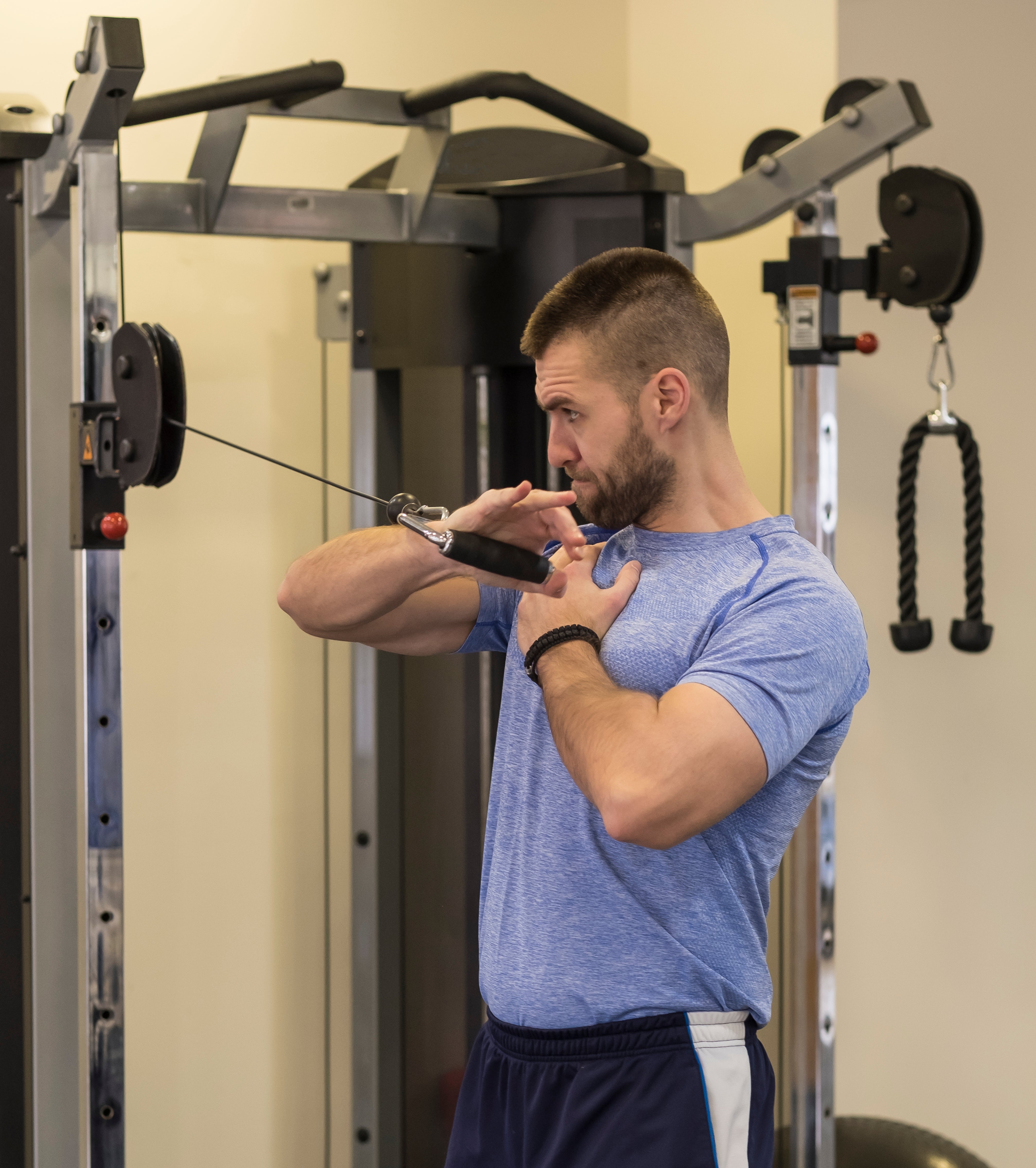 Person successful gym doing look propulsion workout connected a cablegram machine, focusing connected precocious assemblage spot and posture