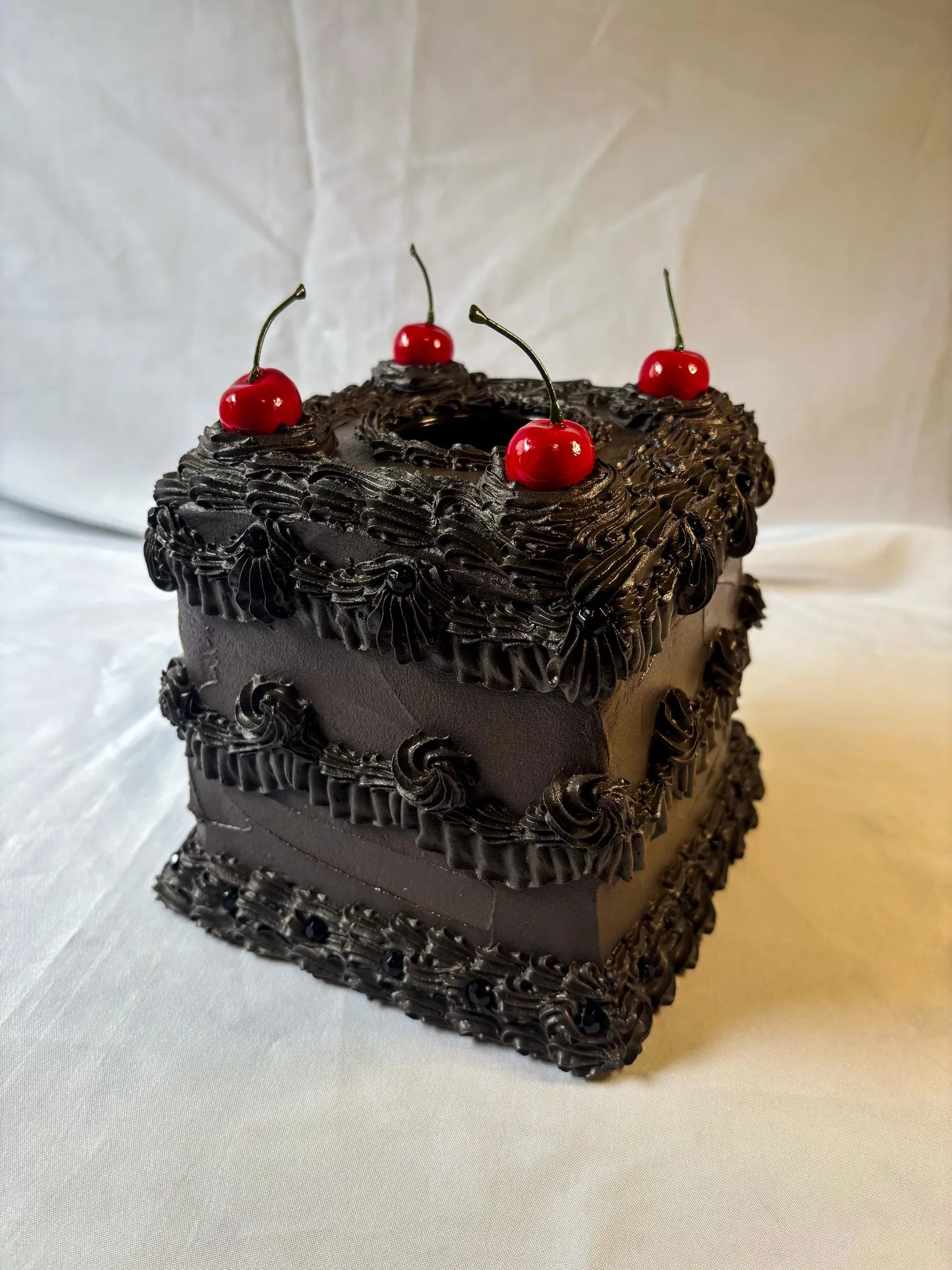 Square barroom   with achromatic  frosting, intricate piping, and 4  cherries connected  top. Elegant and unsocial   design, cleanable   for peculiar   occasions