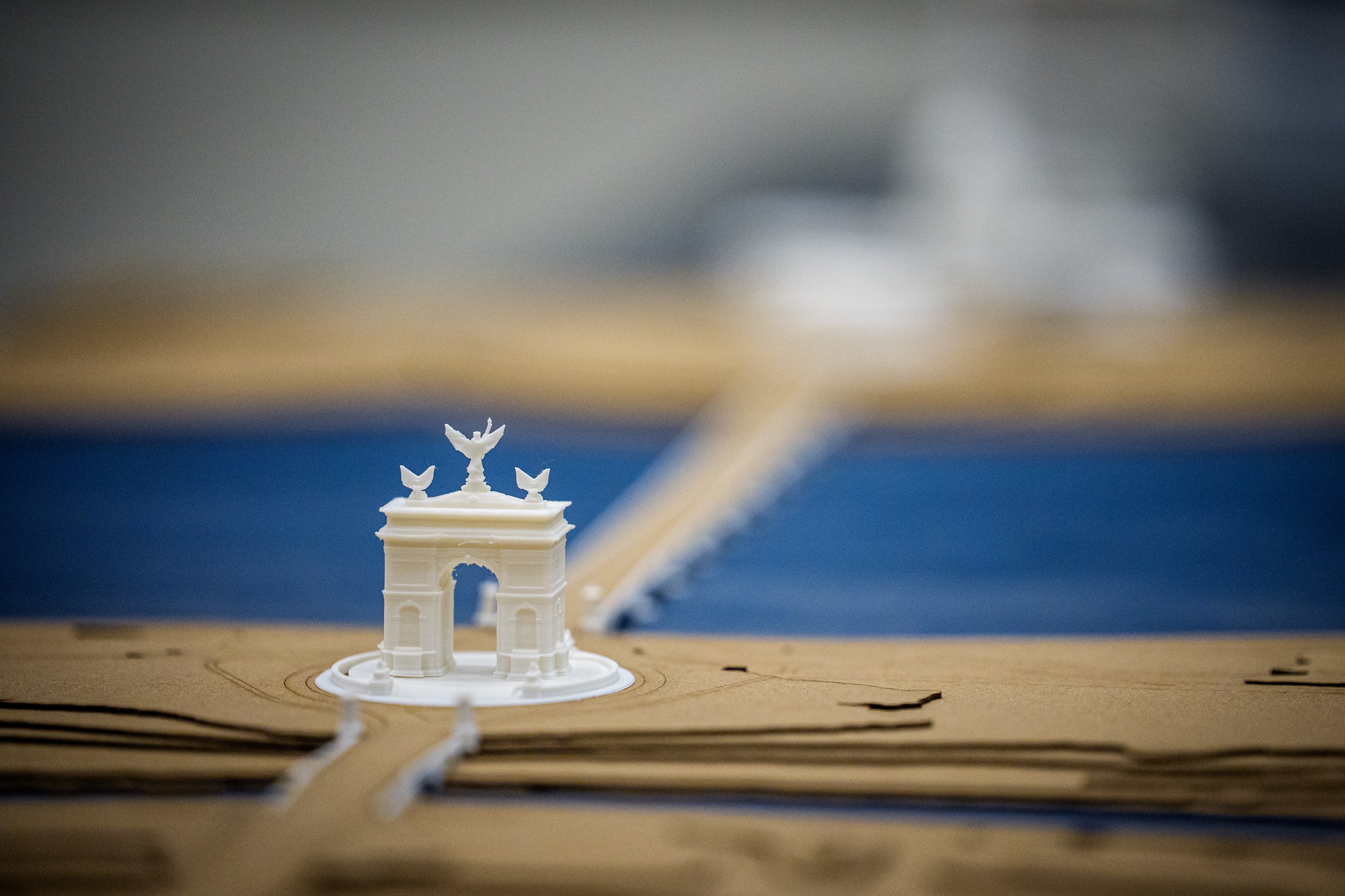 A elaborate miniature exemplary of the Brandenburg Gate, featuring intricate carvings and a chariot connected top, connected a bluish and brownish base