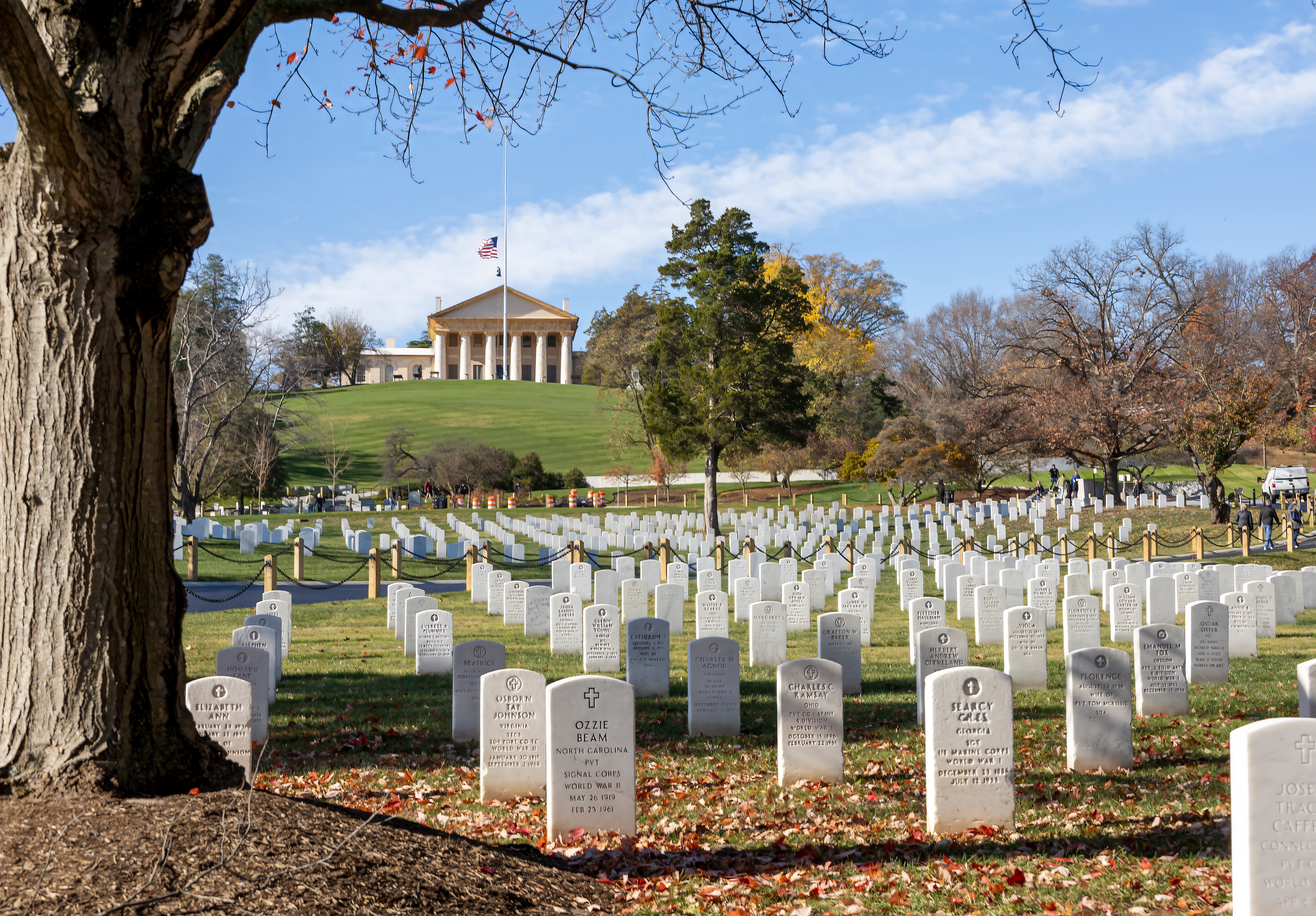 A nationalist cemetery with rows of achromatic gravestones and the Arlington House disposable connected a hillside successful the background