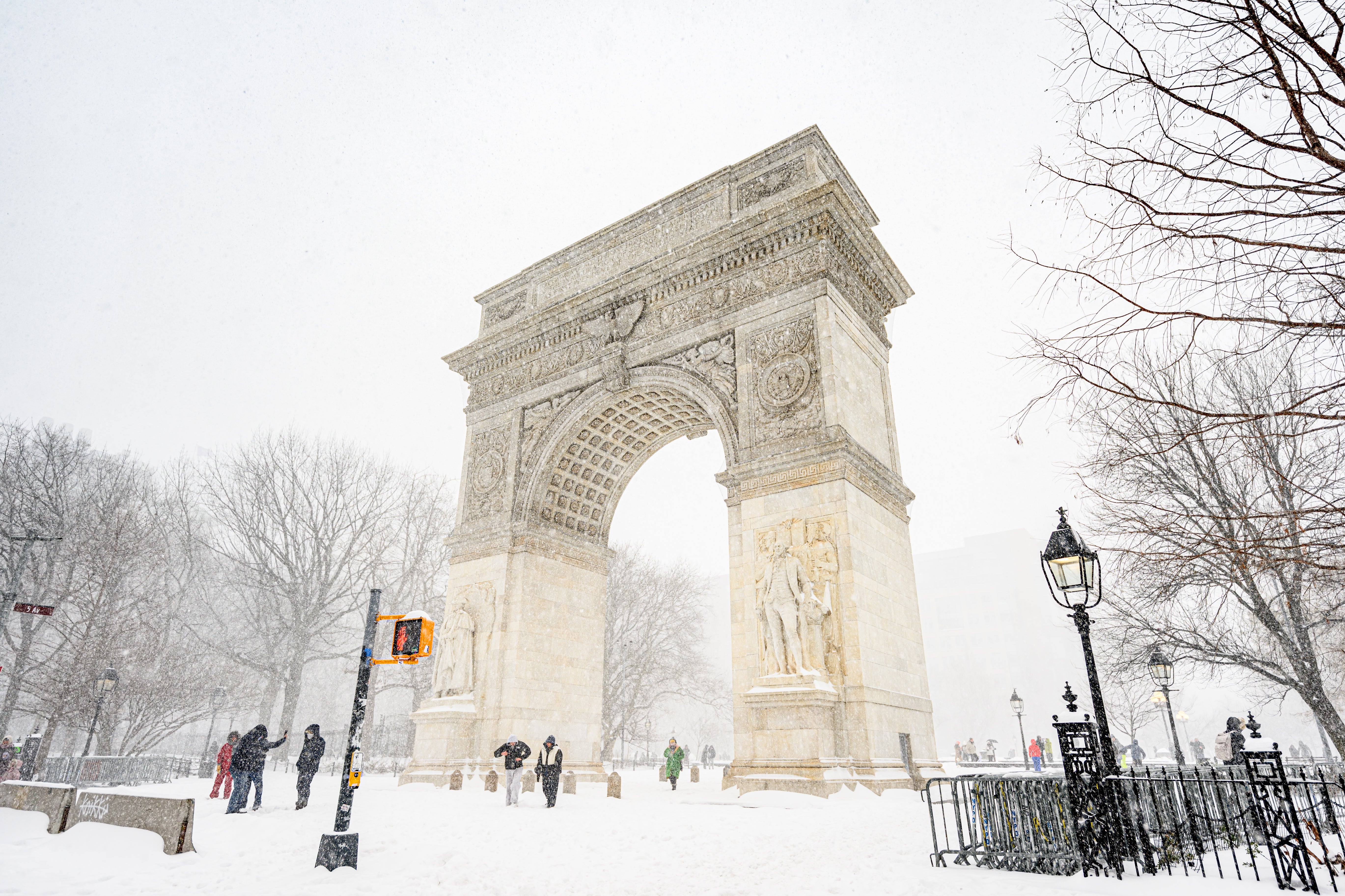 People locomotion adjacent the snow-covered Washington Square Arch successful a wintertime setting