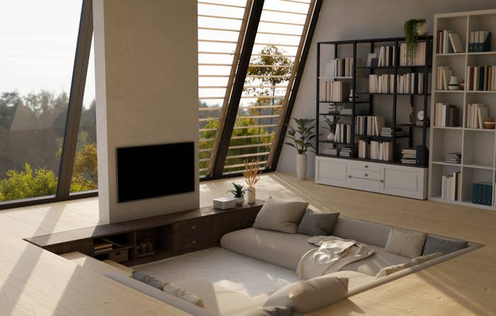 Sunken surviving  country   with modern   furniture, ample  windows, and bookshelves. Cozy seating and minimalist decor make  an inviting space