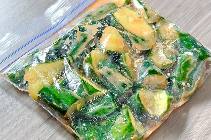 食品用保存袋に入った刻んだキュウリと何らかの調味液が写っています。