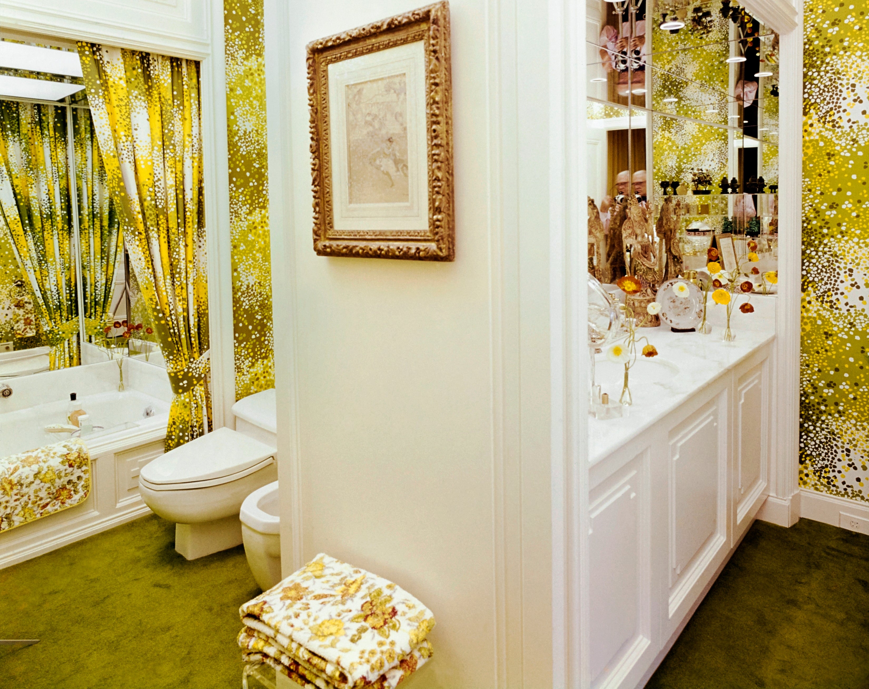 Bathroom with vintage-style floral wallpaper, towels matching the pattern, and a ample reflector reflecting decor and lights