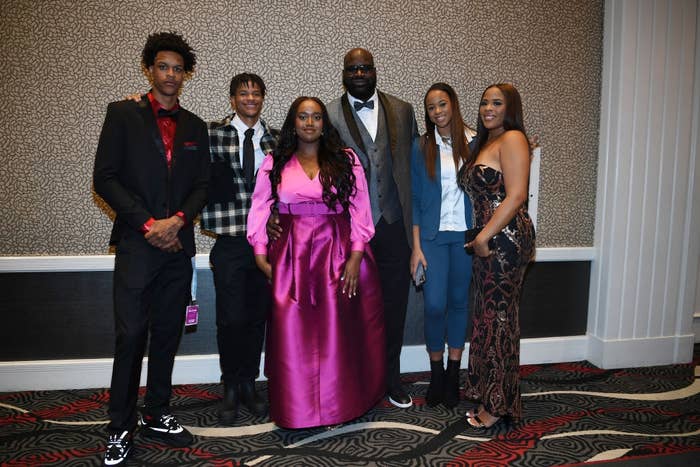 Group of six people dressed in formal and semi-formal attire, posing together at an event
