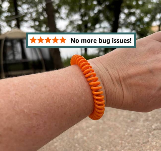 A idiosyncratic wearing a coiled bracelet outdoors, with trees successful the background