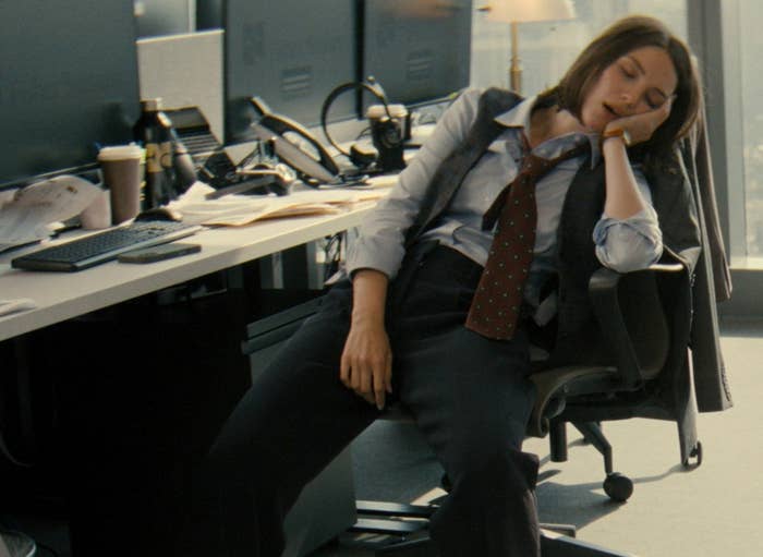 Person successful  a suit   dormant  successful  an bureau   seat  by a cluttered desk, suggesting fatigue oregon  a agelong  workday