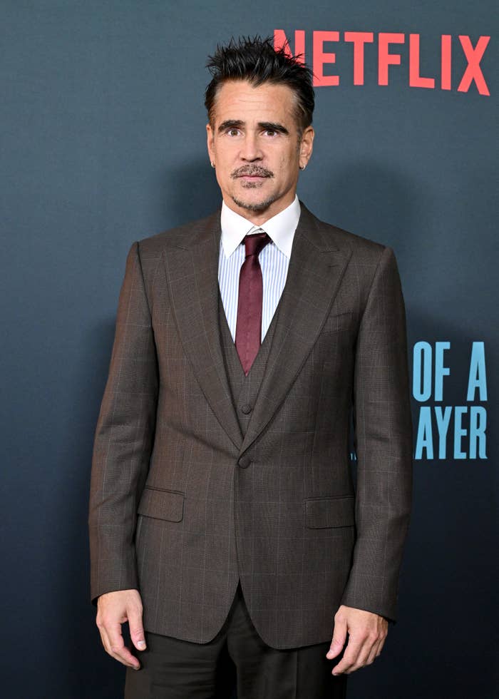 Man in a sharp suit and tie at a Netflix event, posing for photos on the red carpet