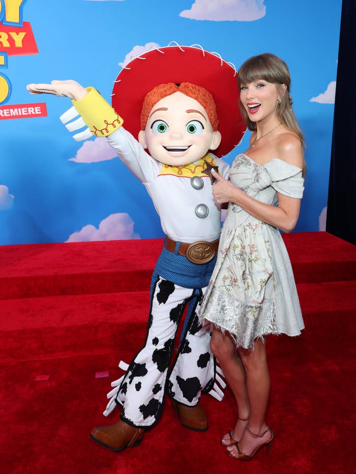 Person successful  an off-shoulder floral formal  poses joyfully with Jessie, a quality  from Toy Story, connected  a reddish  carpet