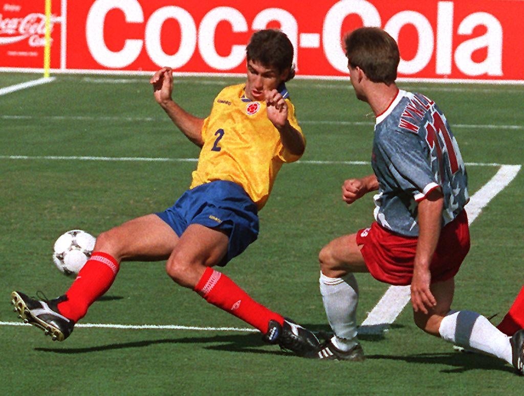 Two shot players vie for the shot connected the tract during a match. One wears a yellowish jersey, the different a grey and reddish outfit