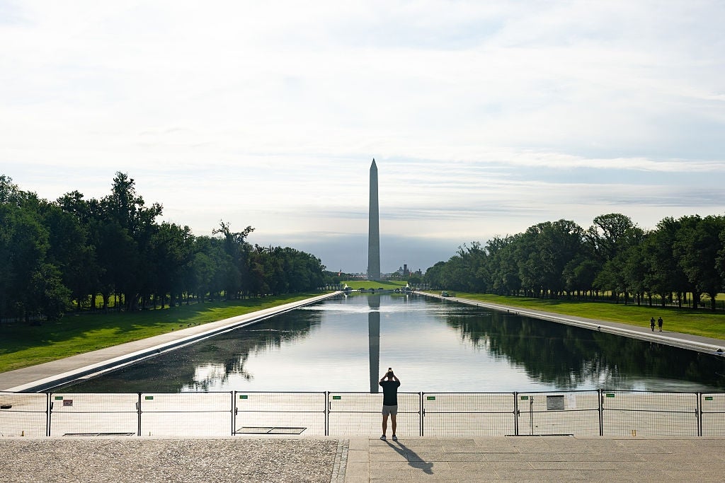 Personen står ved Lincoln Memorial Reflecting Pool, vendt mot Washington-monumentet i det fjerne
