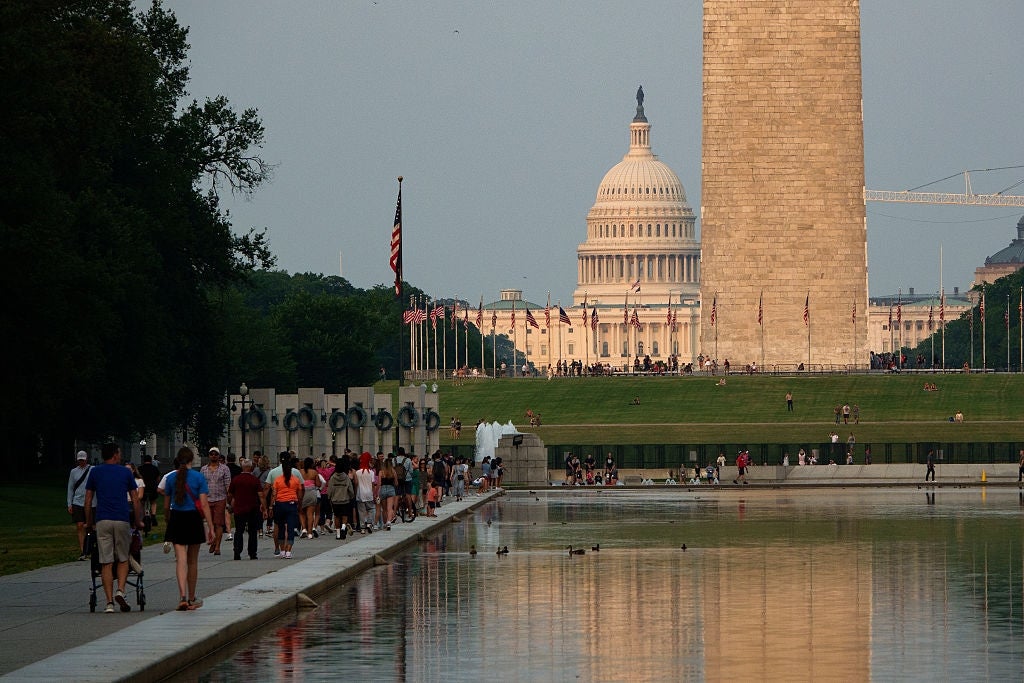 People locomotion on the Reflecting Pool successful Washington, D.C., with the Capitol and Washington Monument successful the background