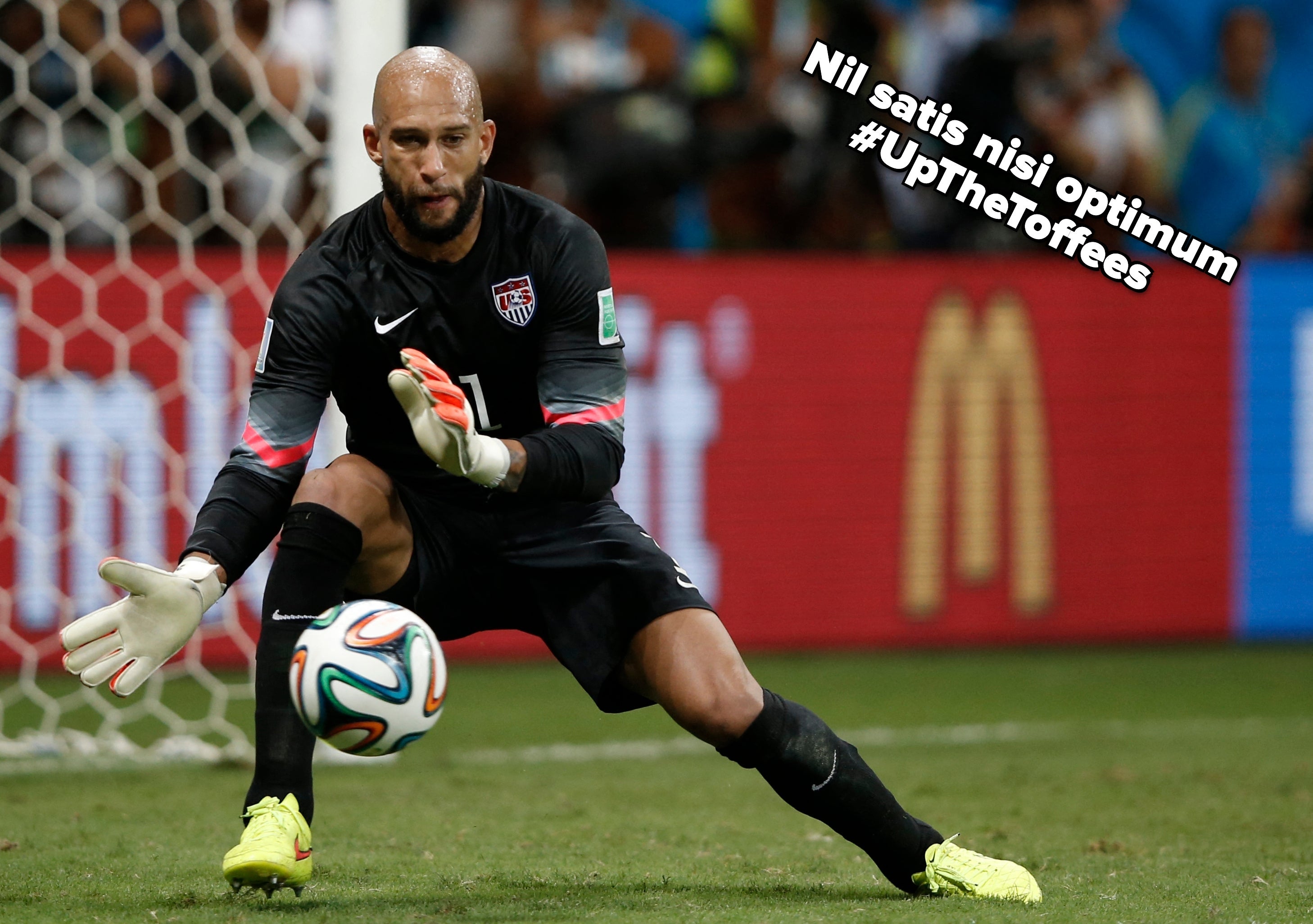 Goalkeeper successful action, focused connected blocking a shot ball, during a lucifer connected the tract with the nett successful the background