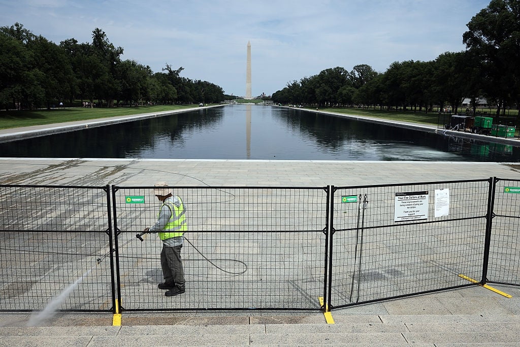 Arbeiderkraft vasker trinn på National Mall med Washington Monument i bakgrunnen. Sikkerhetsbarrierer blokkerer tilgangen til det reflekterende bassenget
