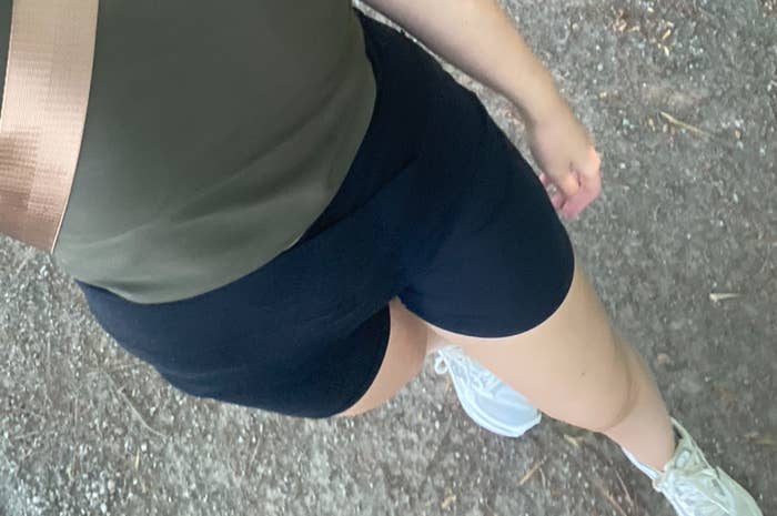 Person taking a selfie portion    walking, wearing diversion  shorts, a top, and sneakers