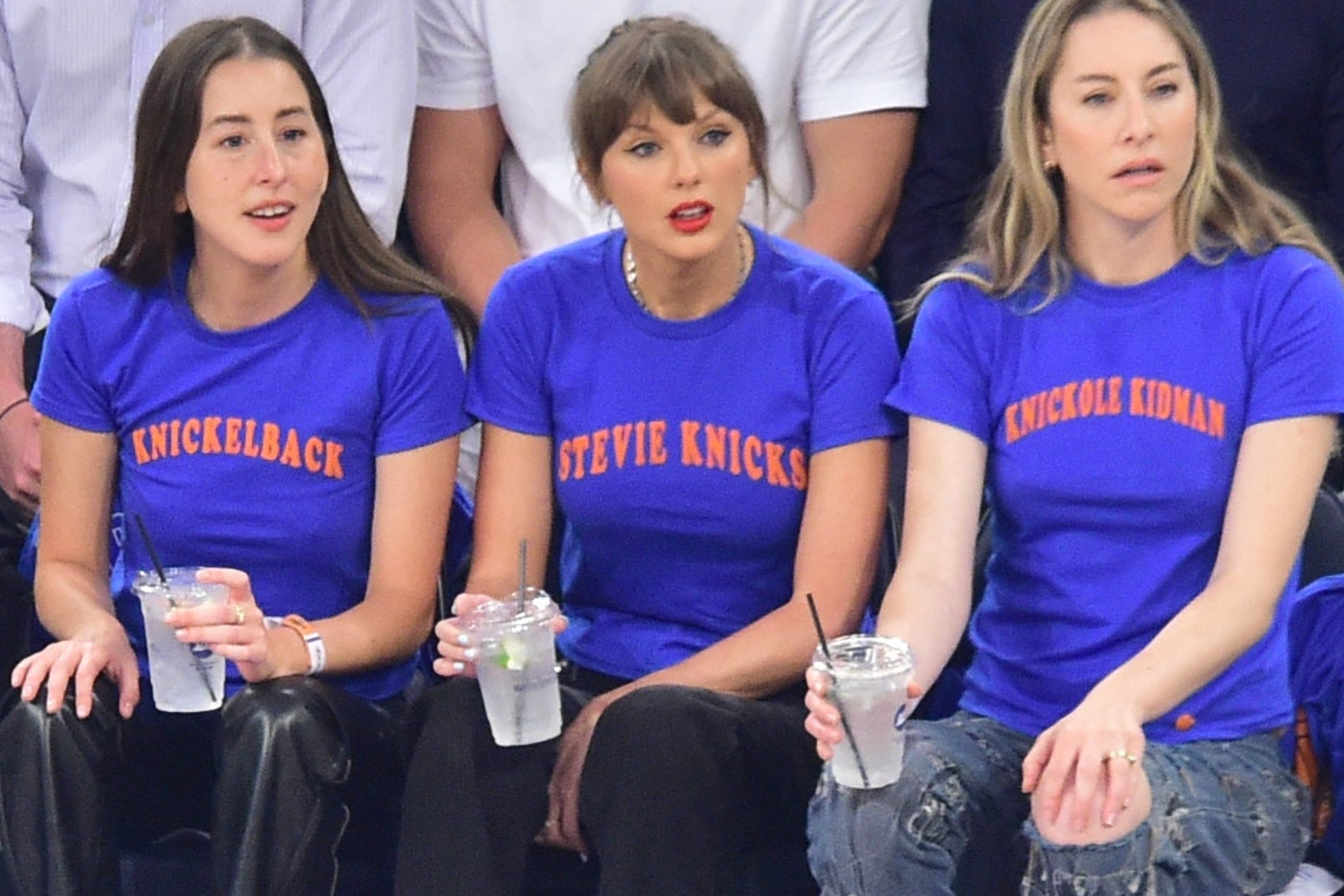 A radical of radical sits courtside astatine a hoops game, with immoderate wearing matching squad shirts