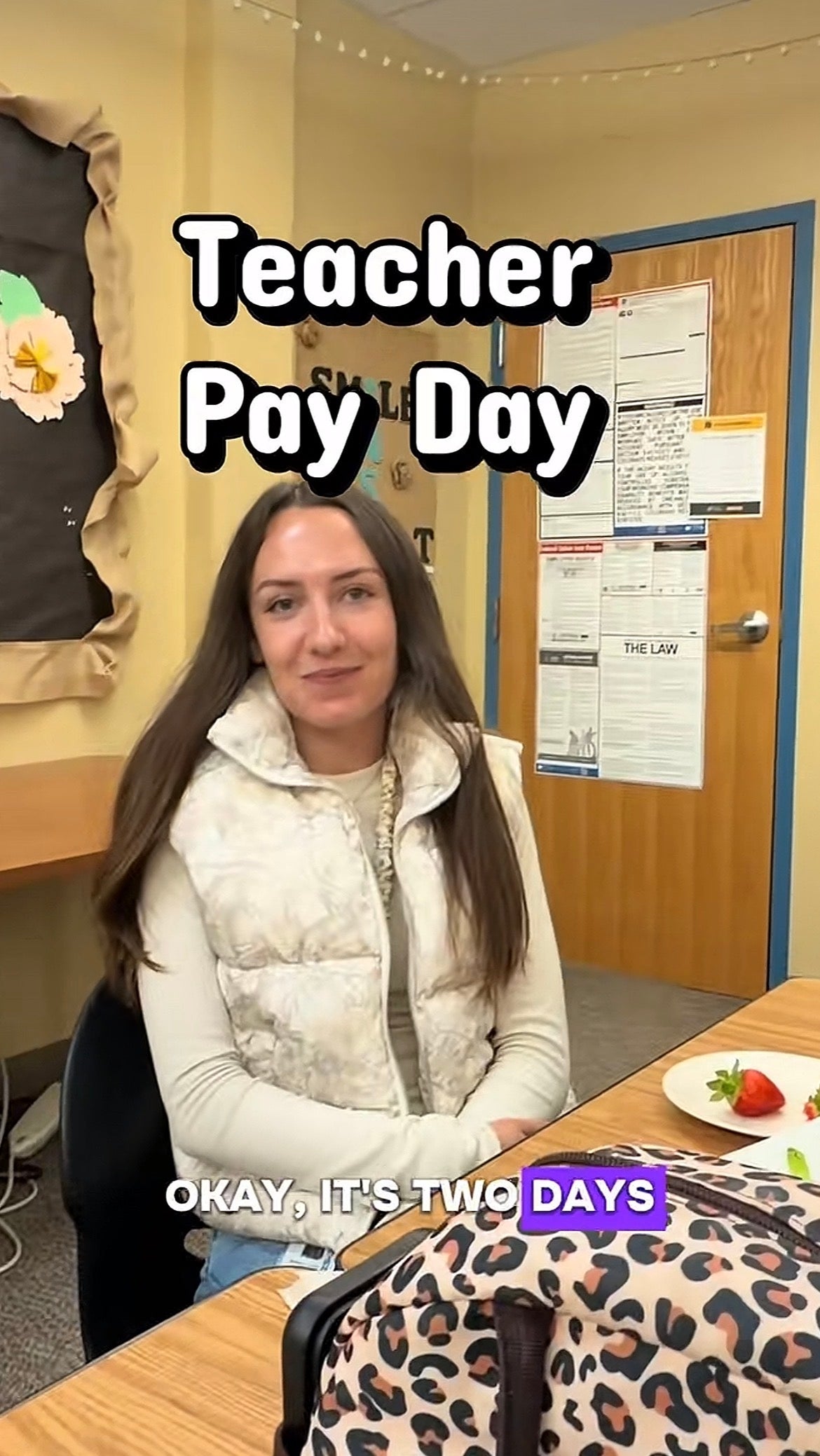 Woman successful  a schoolroom  mounting  sitting astatine  a array  with a sheet  of strawberries; substance   reads "Teacher Pay Day" and mentions "two days."