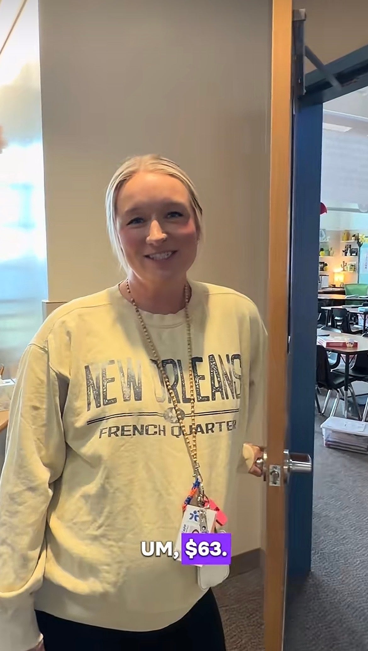 Person stands successful  a schoolroom  doorway, wearing a "New Orleans" sweatshirt. Text connected  the representation  reads, "Um, $63."