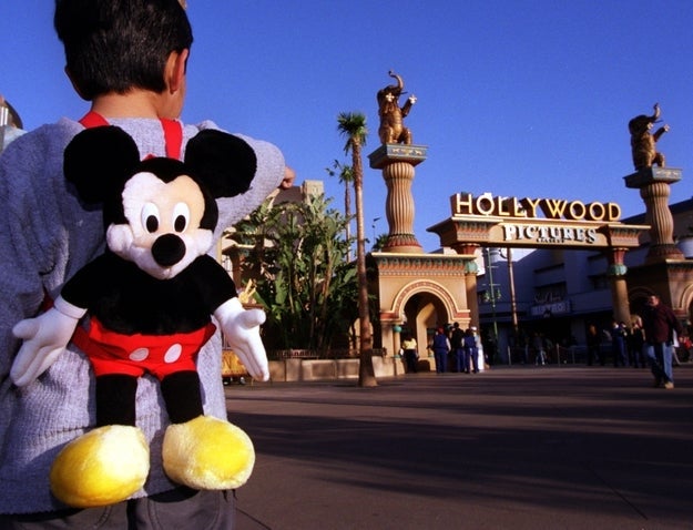 Child with Mickey Mouse backpack pointing astatine taxable parkland entrance