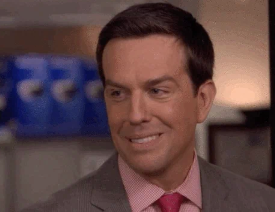 Man successful a suit and necktie smiling, caput turned somewhat to the side. Office mounting successful the background