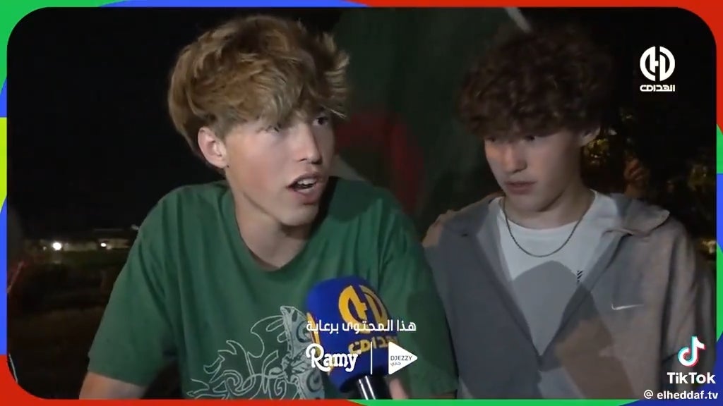 Two young individuals springiness an interview; 1 is speaking into a microphone labeled "Ramy" with an Arabic logo