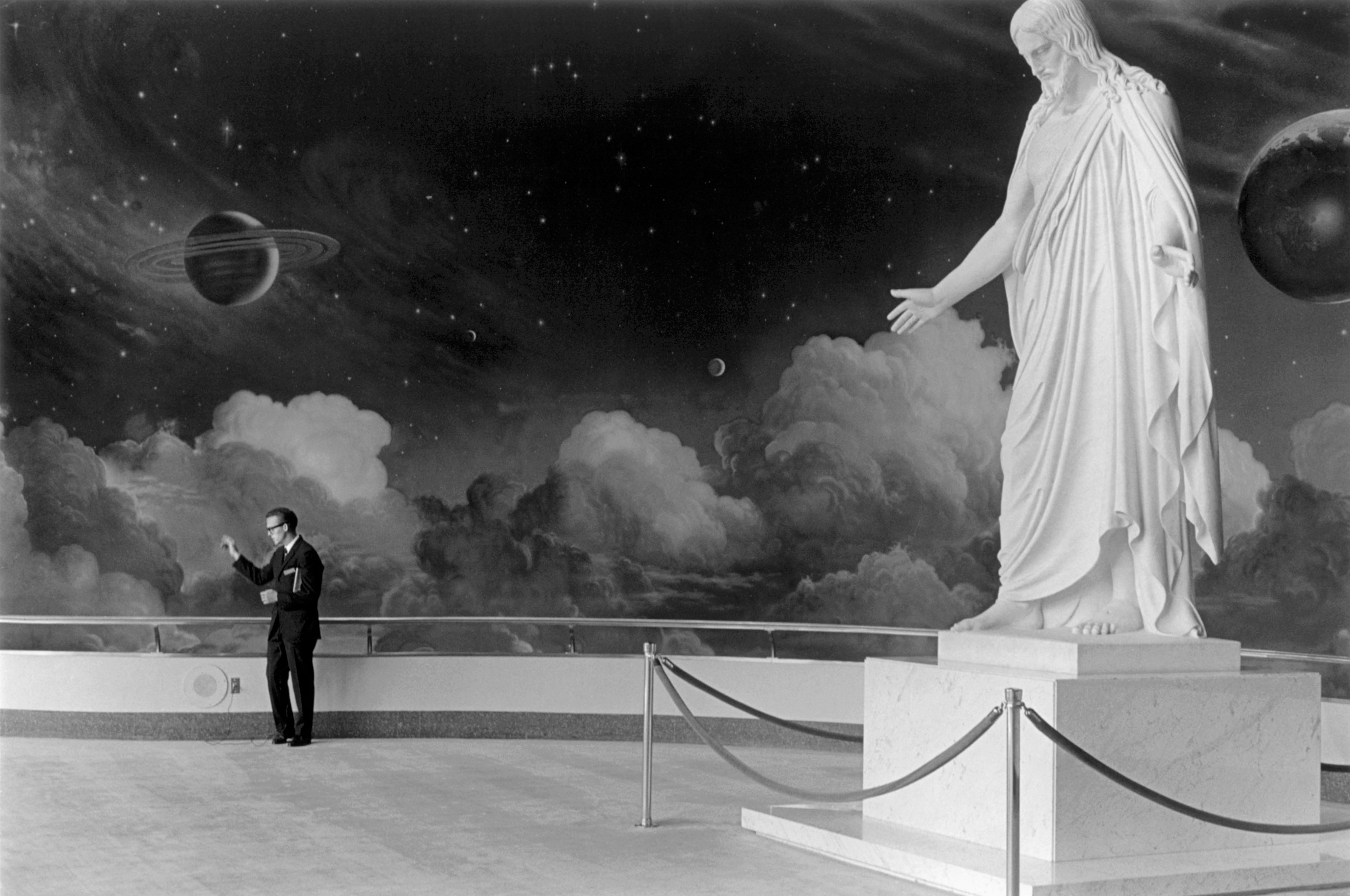 A antheral stands successful beforehand of a ample statue of Christ, with an outer abstraction mural arsenic the backdrop