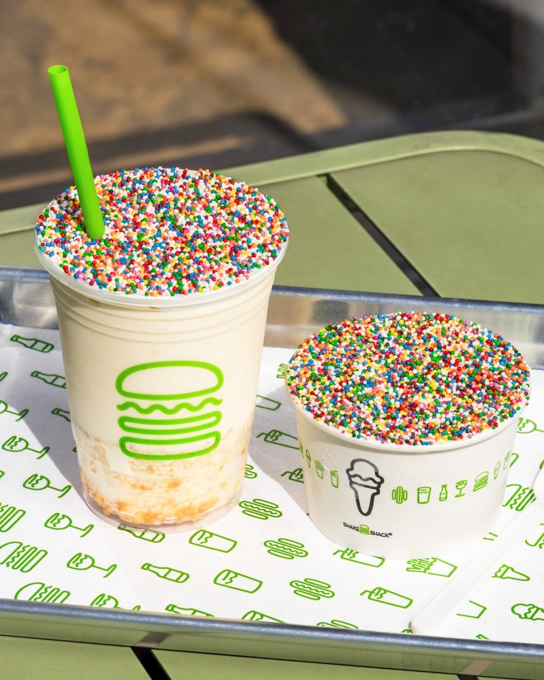 Milkshake and ice cream cup on a tray, topped with rainbow sprinkles