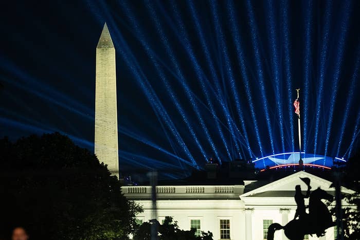 Nighttime presumption    of the Washington Monument with beams of airy  and the White House successful  the foreground, creating a melodramatic  scene