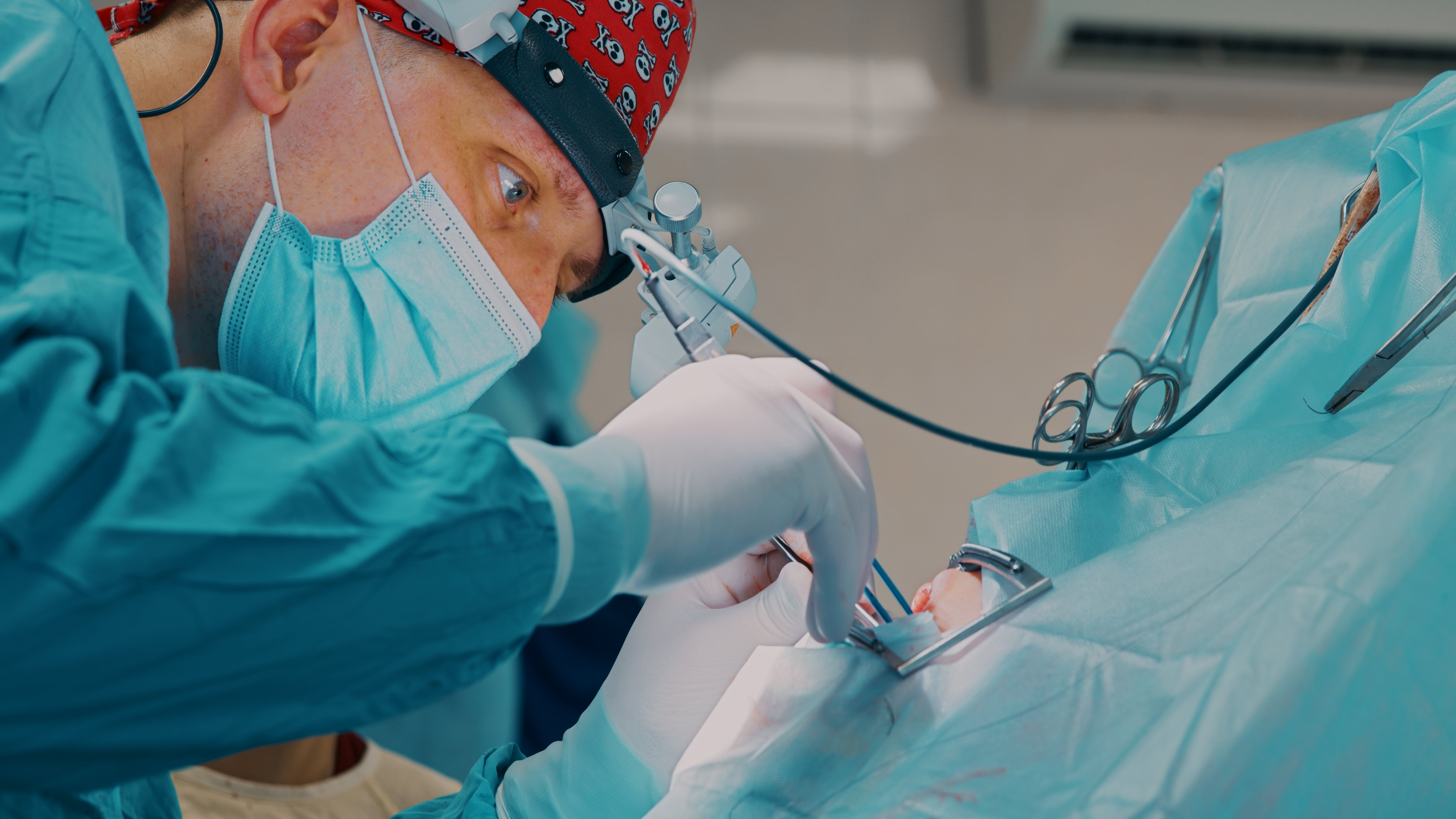 A surgeon successful scrubs and a headdress performs a delicate operation, focused intently connected the procedure