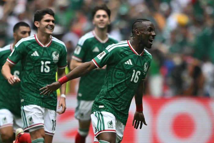 Soccer players observe  connected  the tract  during a match, wearing greenish  jerseys. The nonfiction  is related to travel
