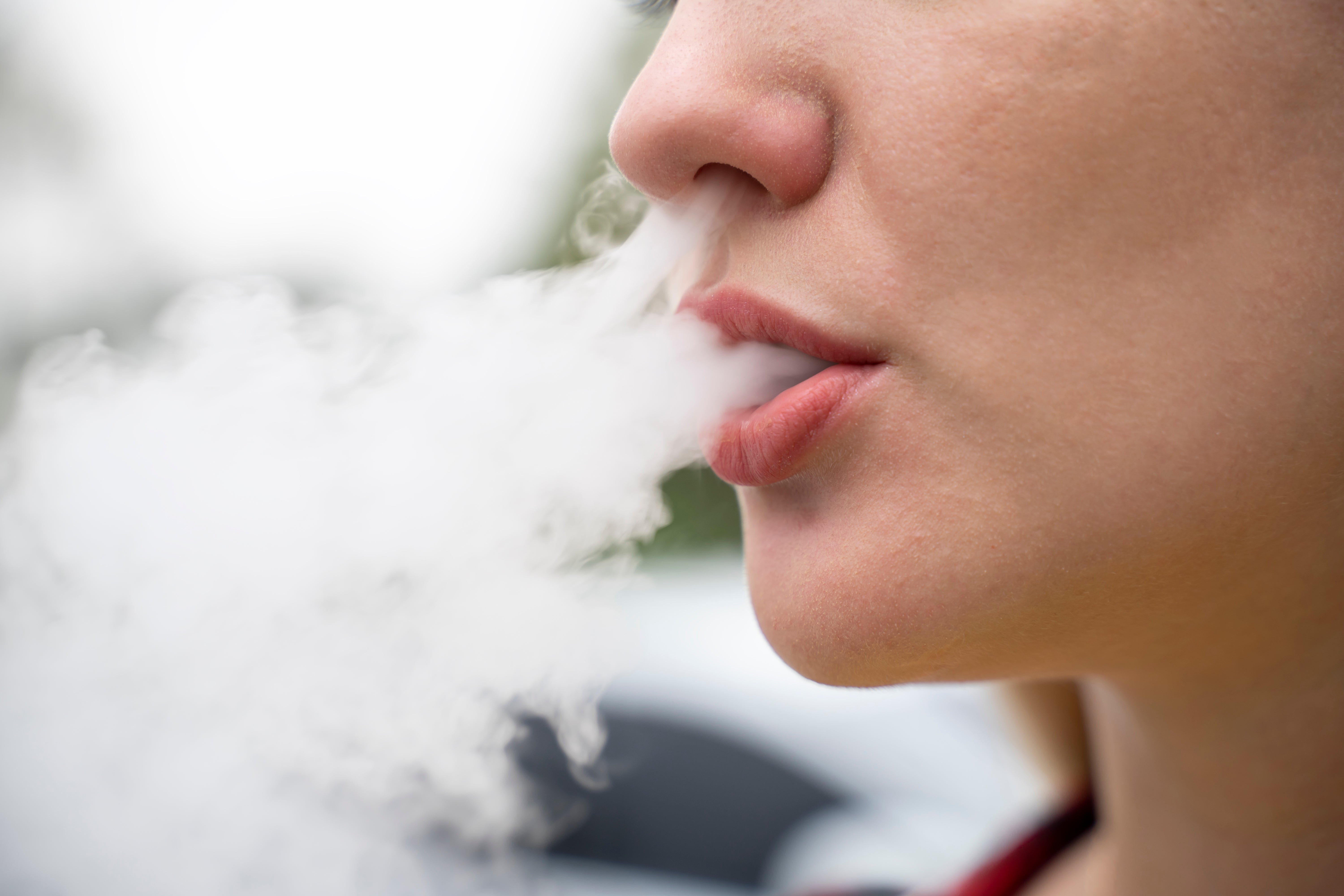 Person exhaling vapor, close-up of their rima and vapor cloud