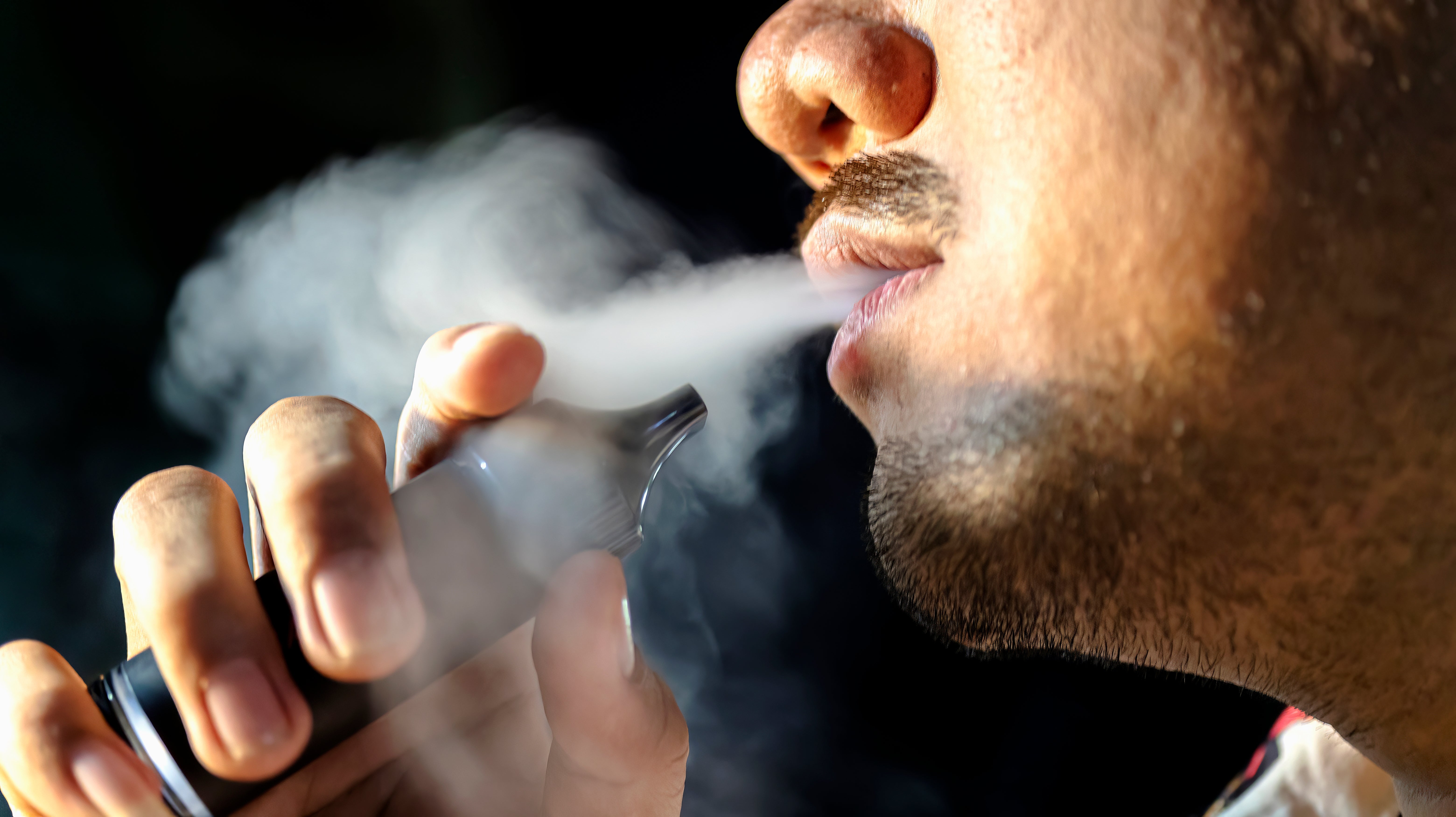Person utilizing a vape instrumentality with disposable vapor, highlighting wellness concerns related to vaping