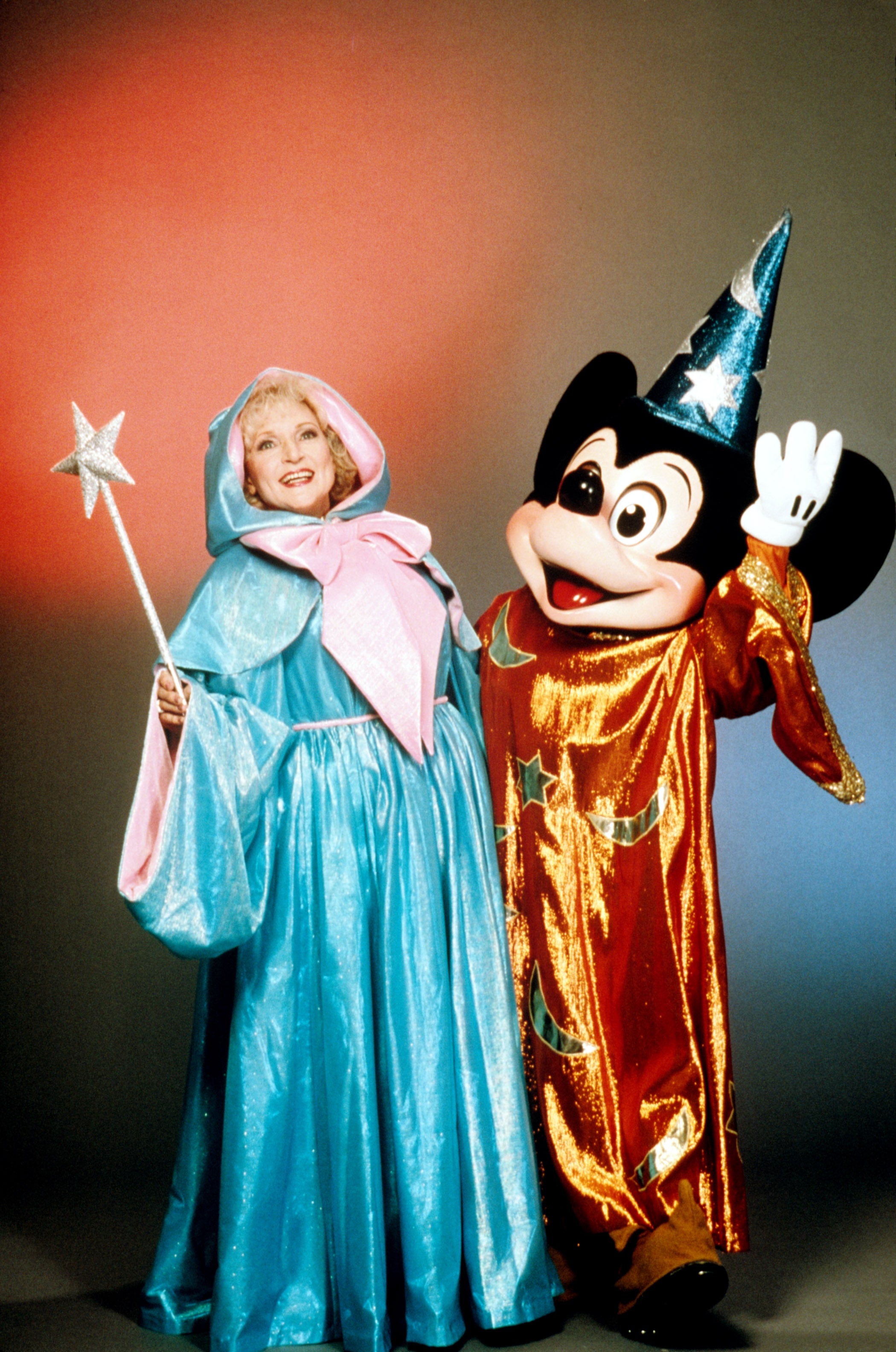 Person successful  a fairy godmother costume with a prima  wand stands beside a quality  successful  a wizard outfit with a starry hat