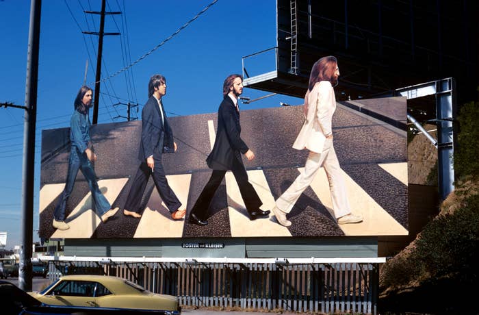 Billboard of 4  radical   crossing a thoroughfare  successful  single-file, reminiscent of an iconic medium  cover