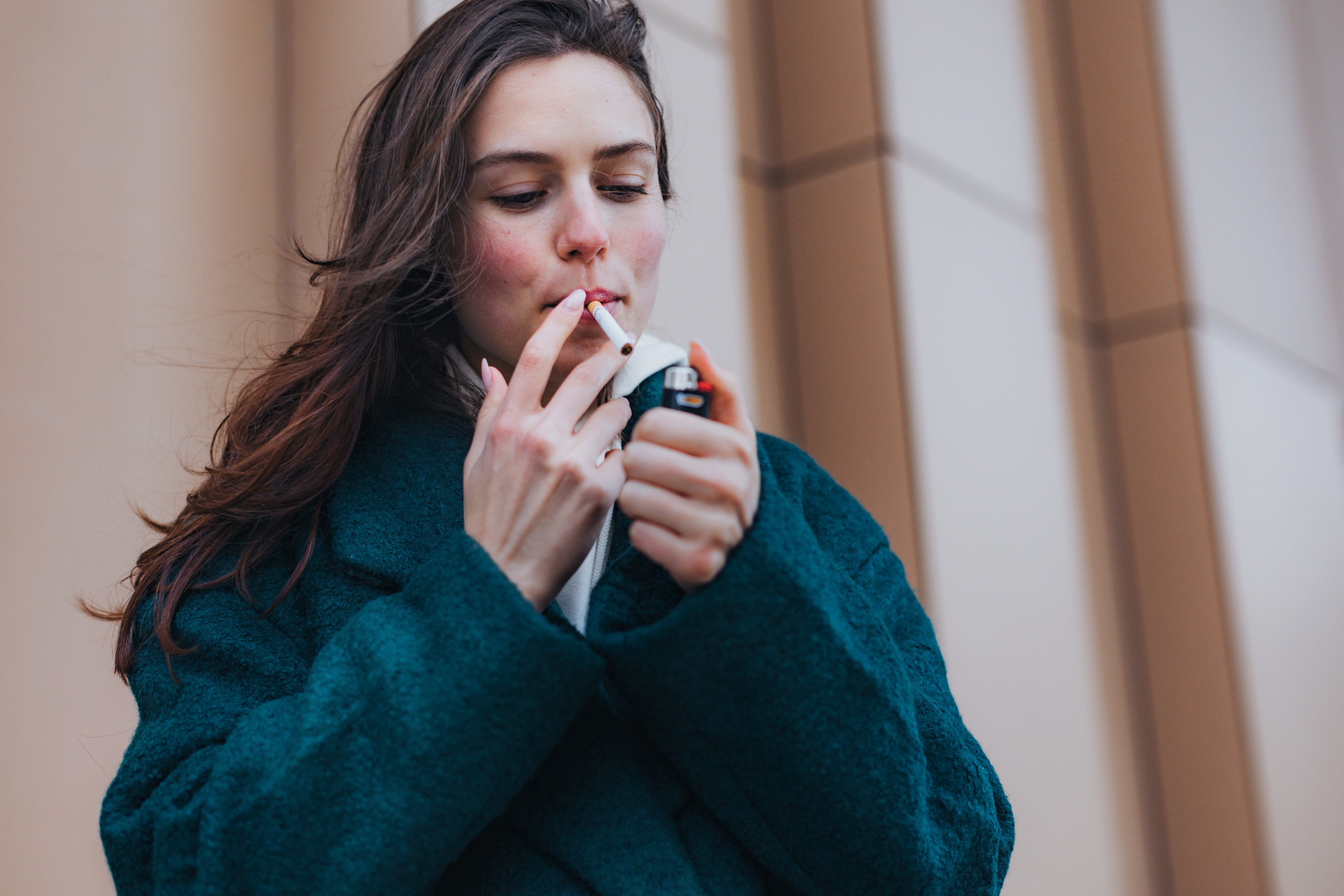 Person successful a overgarment lighting a cigaret outdoors