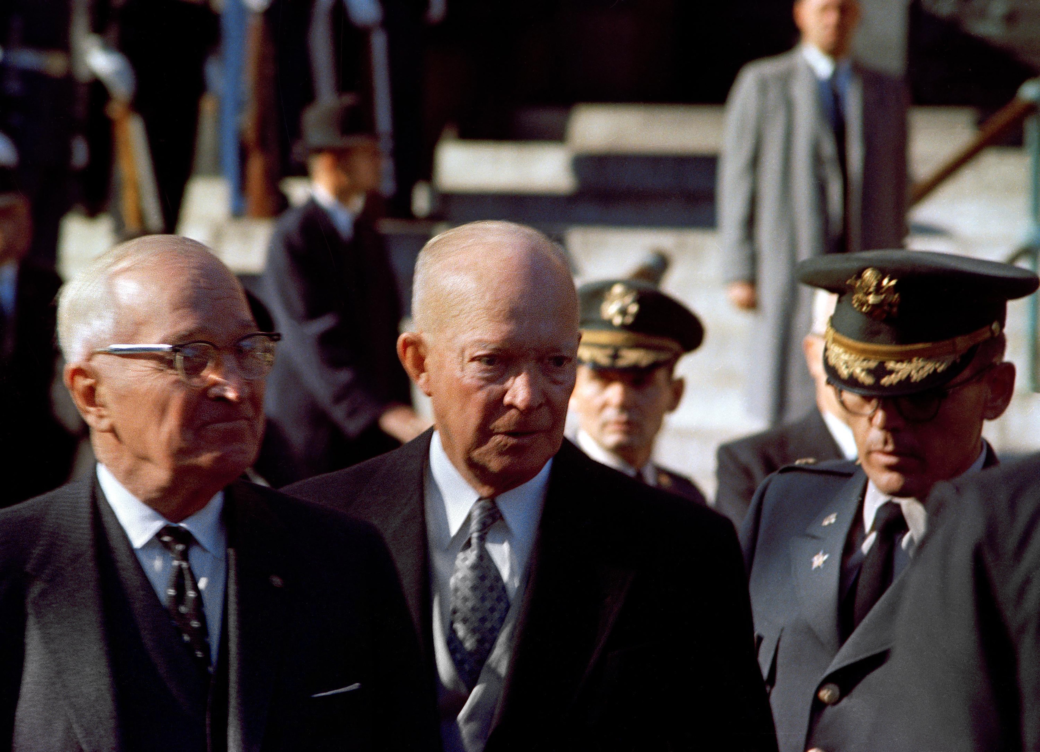 A humanities  photograph  featuring 2  older men successful  suits and a subject   serviceman  successful  uniform, lasting  outdoors with a tiny  radical  of people
