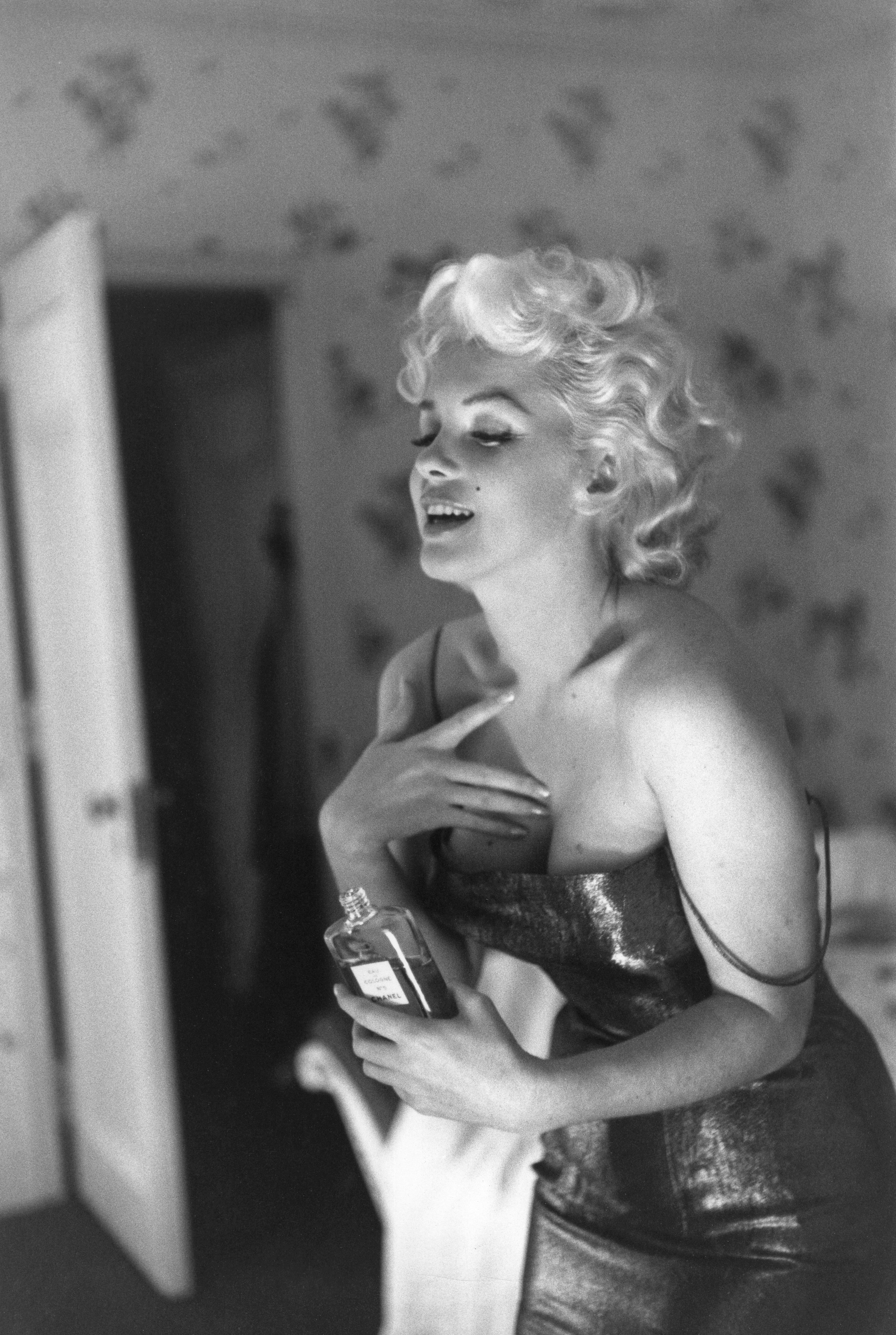 Person successful  a glamorous strapless gown, holding a perfume vessel  and laughing successful  a candid moment, acceptable   successful  an elegant room
