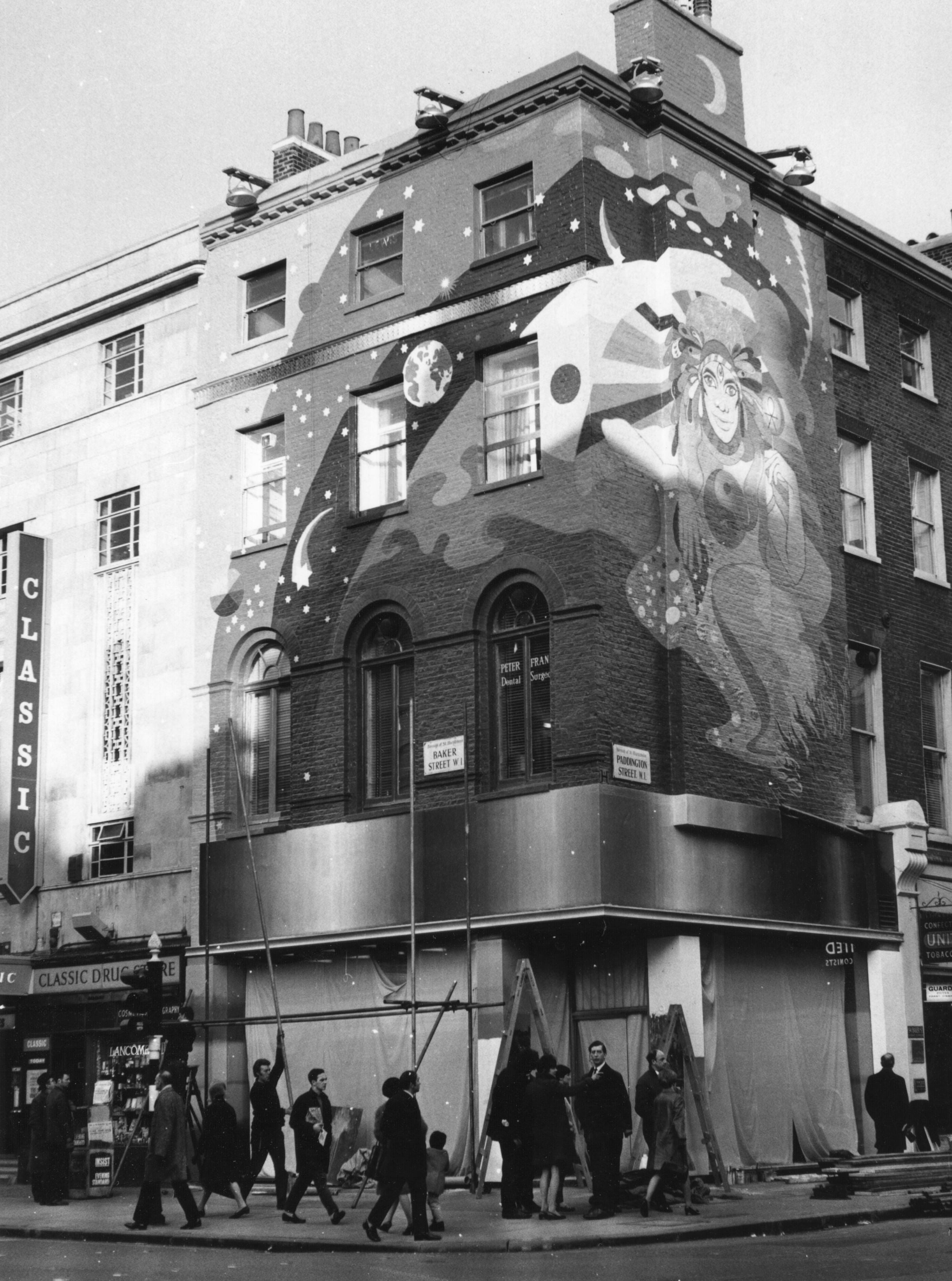 Building with a ample  mural featuring a celestial fig  successful  a flowing gown. People locomotion  by connected  the sidewalk below
