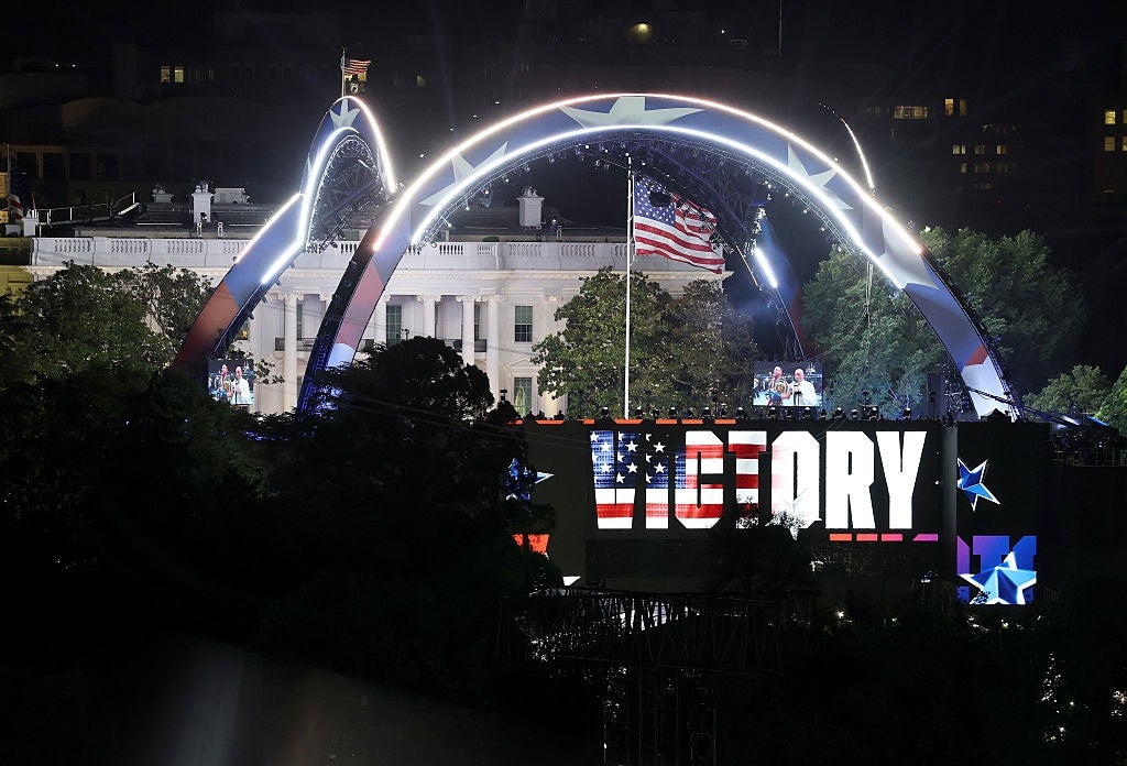 Outdoor performance astatine nighttime with lit signifier and "VICTORY" sign; American emblem waves supra audience