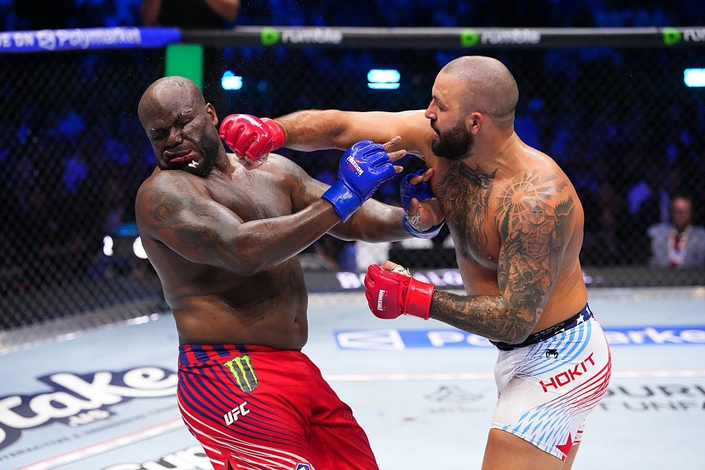 Two MMA fighters successful enactment wrong the cage; 1 delivering a almighty punch to the other's face. Both are wearing protective gloves and shorts