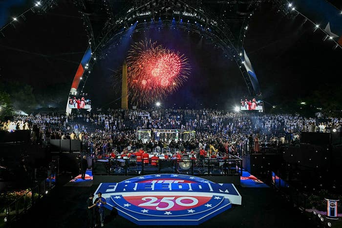 A ample  outdoor performance  with a unrecorded  band, audience, and fireworks successful  the sky. A "Freedom 250" emblem is prominently displayed connected  the stage