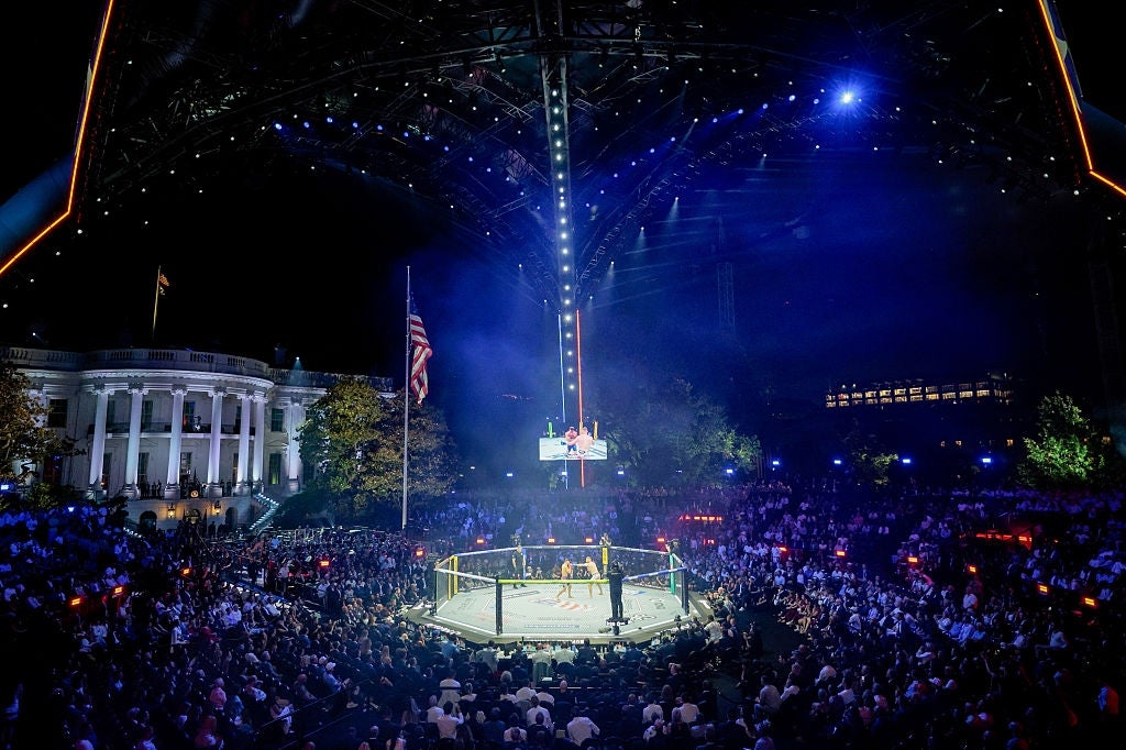 An outdoor mixed martial arts lawsuit is taking spot astatine nighttime adjacent a large, iconic gathering with a dome and columns