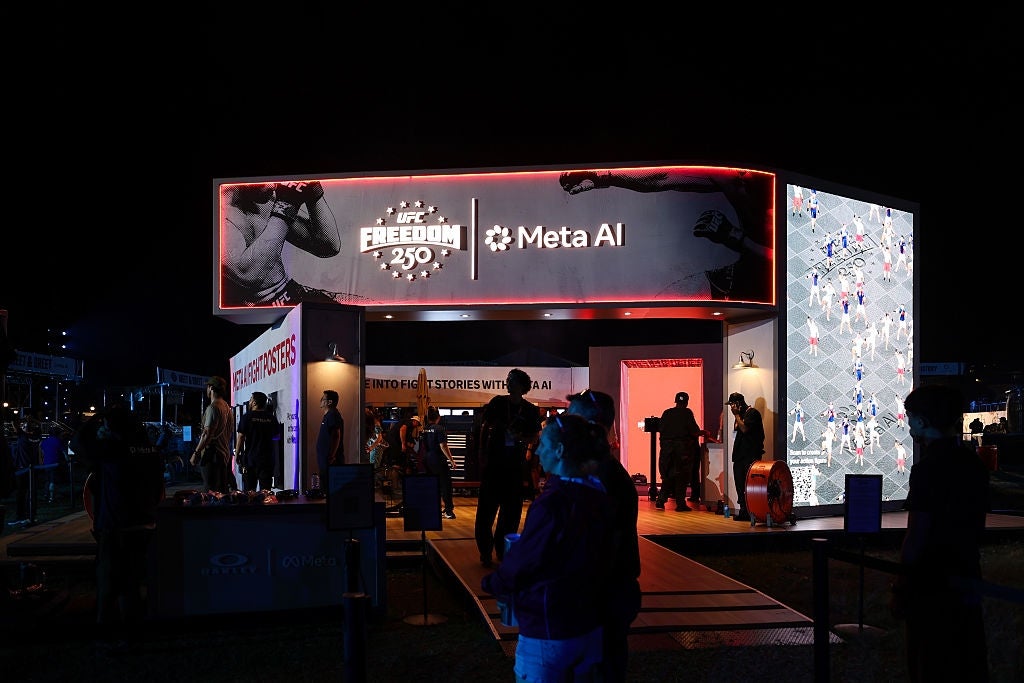 People gathered extracurricular a tech-themed grounds booth featuring "Meta AI" signage astatine a nighttime event