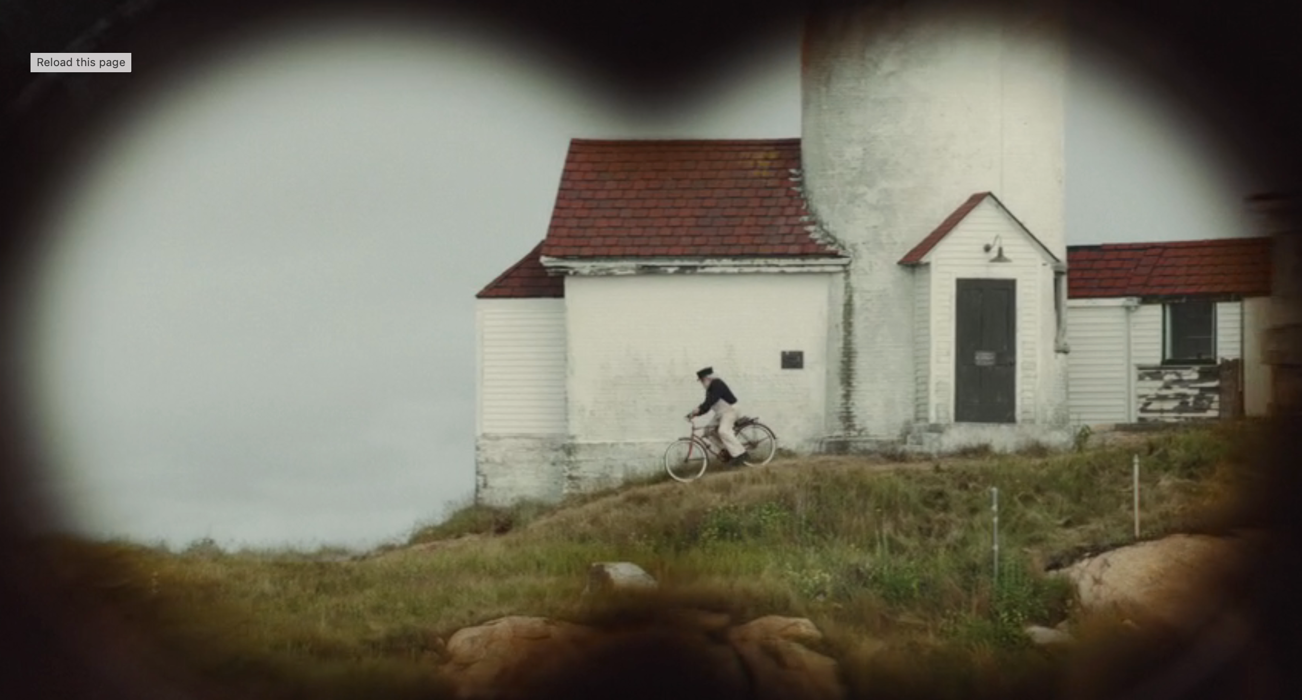 A idiosyncratic   is riding a bicycle past   a lighthouse, viewed arsenic  if done  binoculars