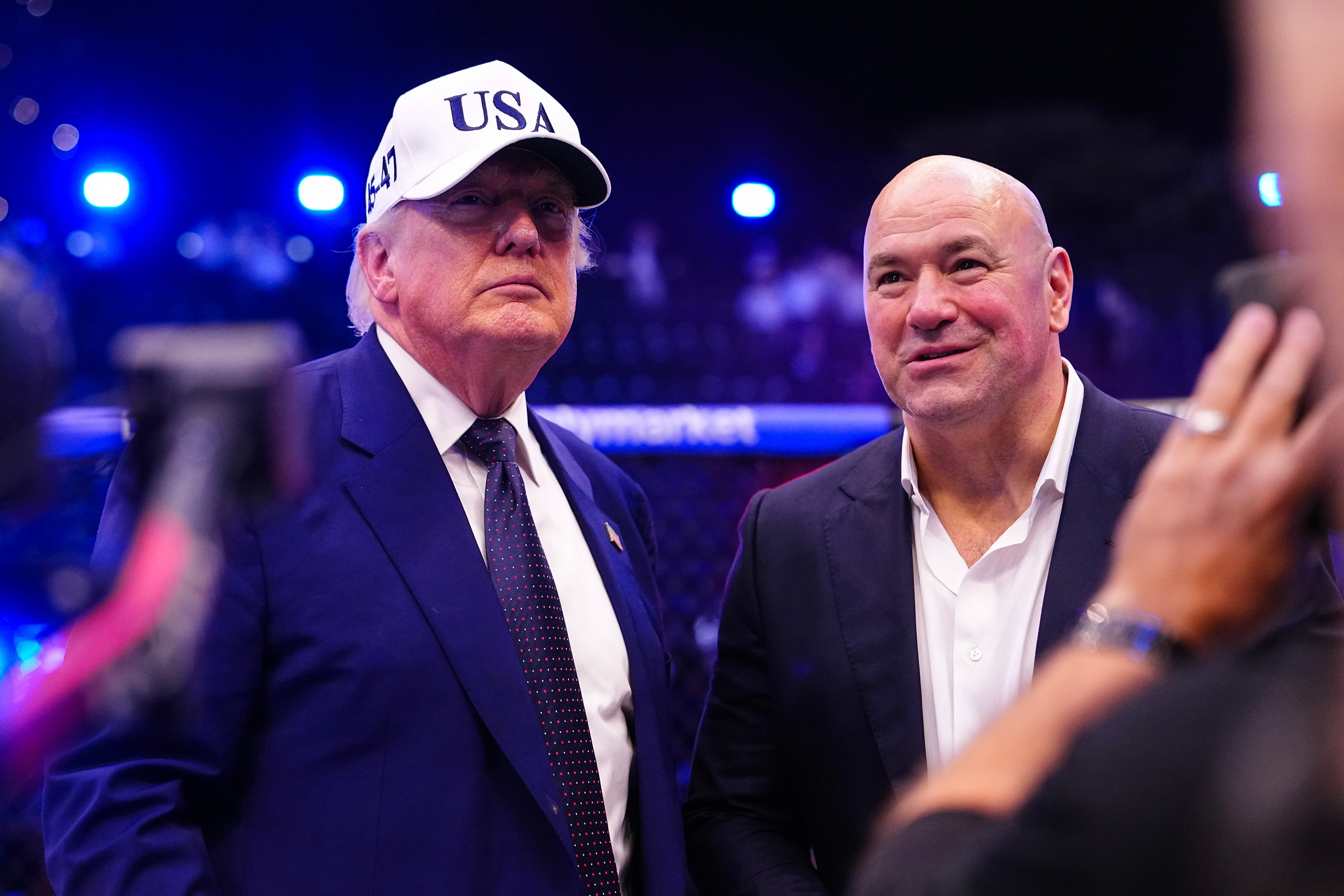 Two men astatine an event, 1 wearing a suit with a "USA" cap. They look to beryllium successful speech oregon posing for a photo